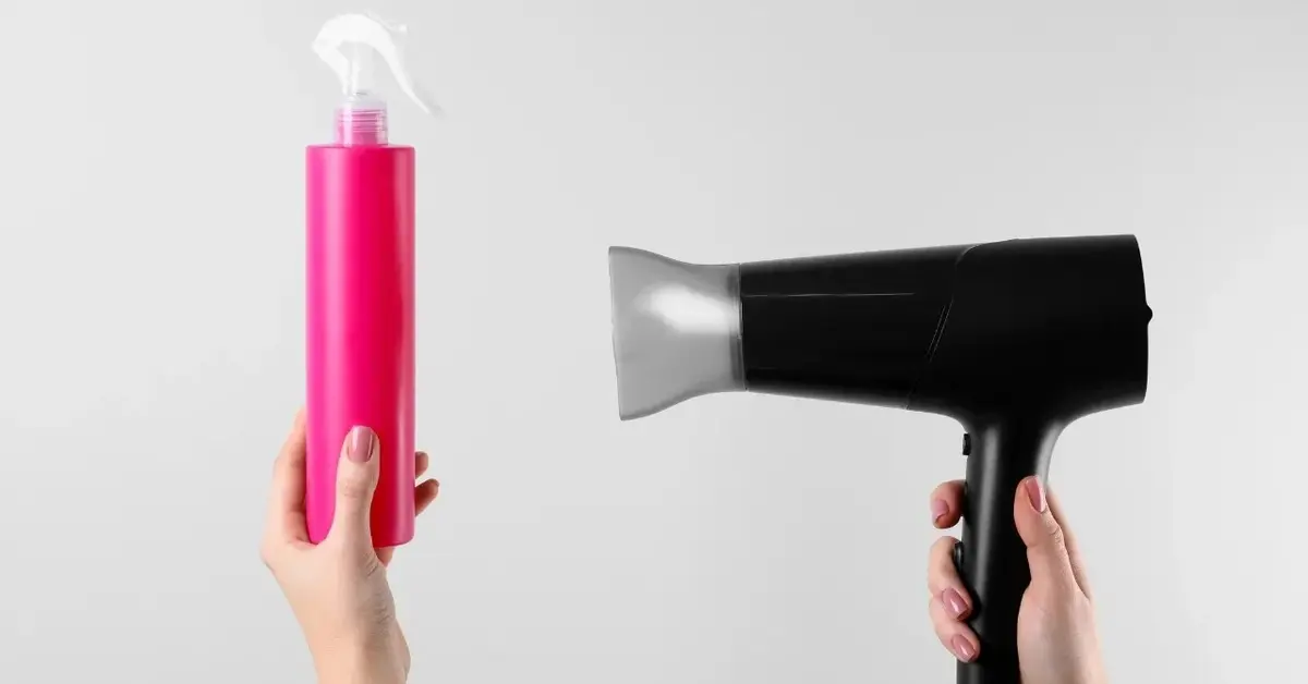 Suszarka i sprey w trzymany w dłoniach na białym tle różowej buteleczce