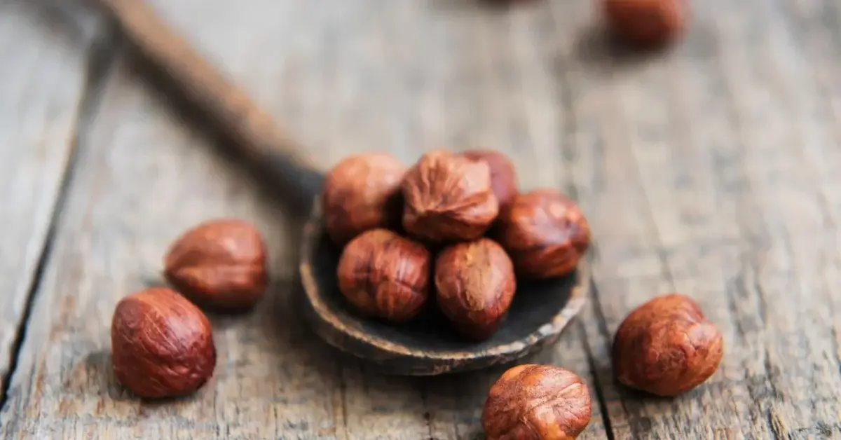 Prażone orzechy laskowe na drewnianej łyżce
