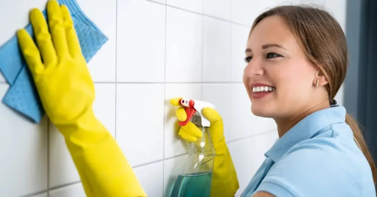 Kobieta czyszcząca fugi gąbką 