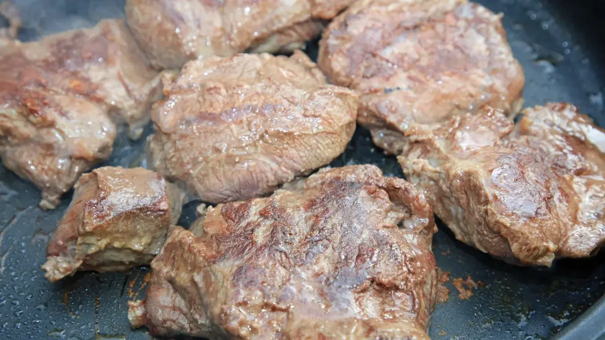 Policzki wołowe, kawałki mięsa smażone na patelni