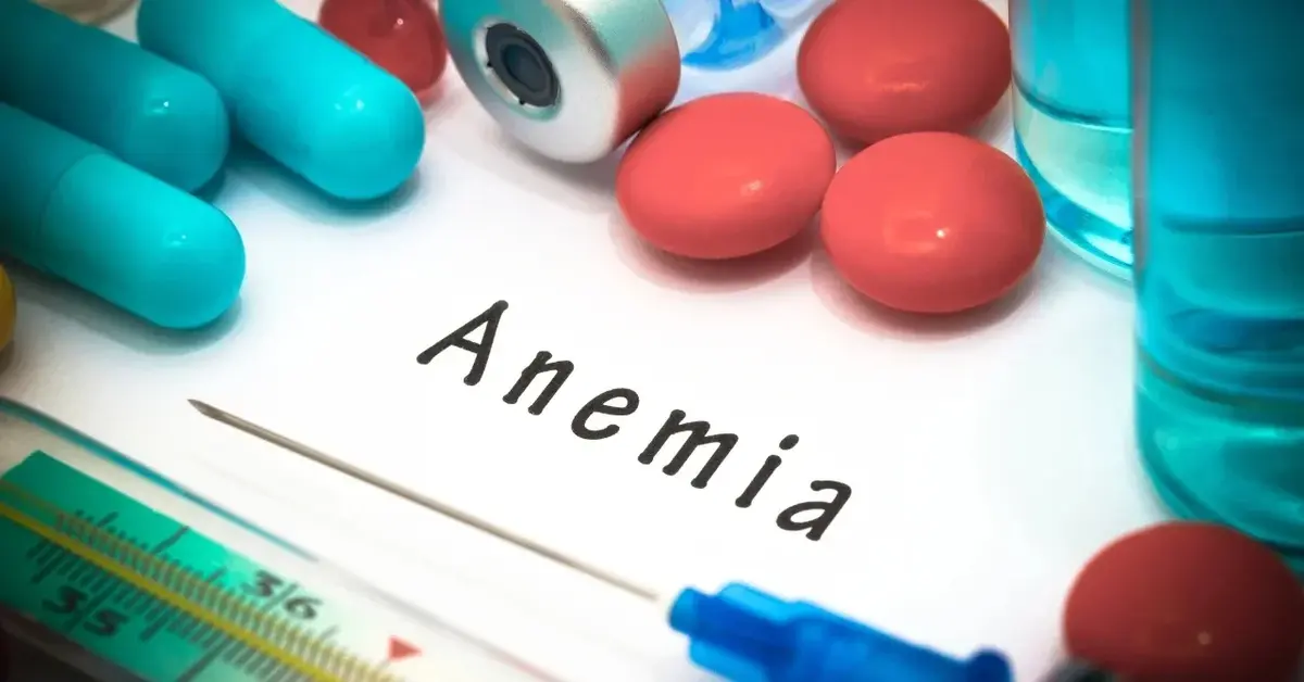 Kartka z napisem anemia, obok tabletki i igła od strzykawki