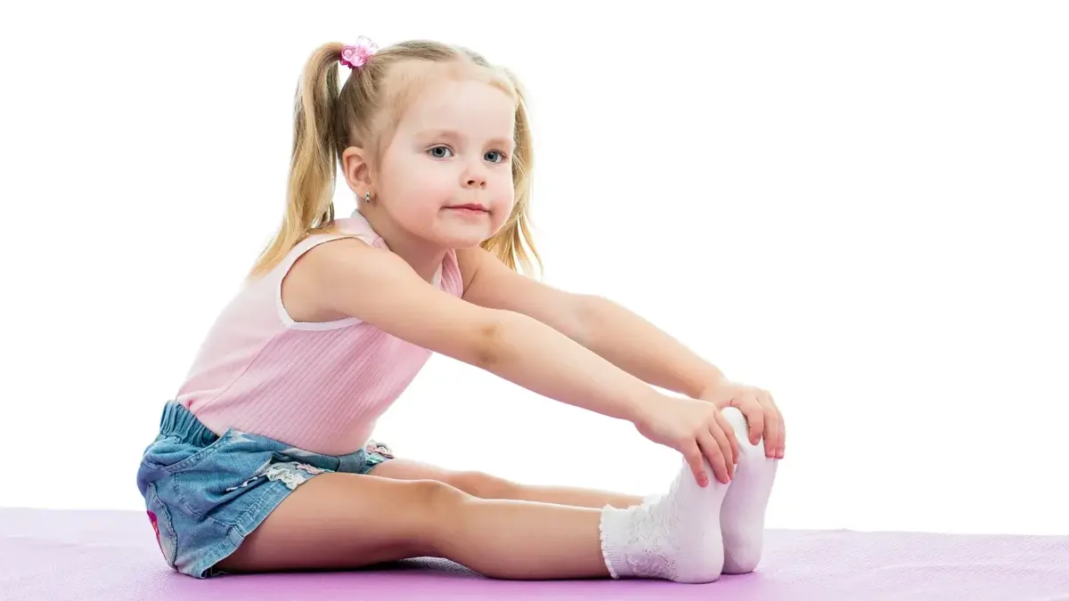 Mała dziewczynka ćwicząca na białym tle 
