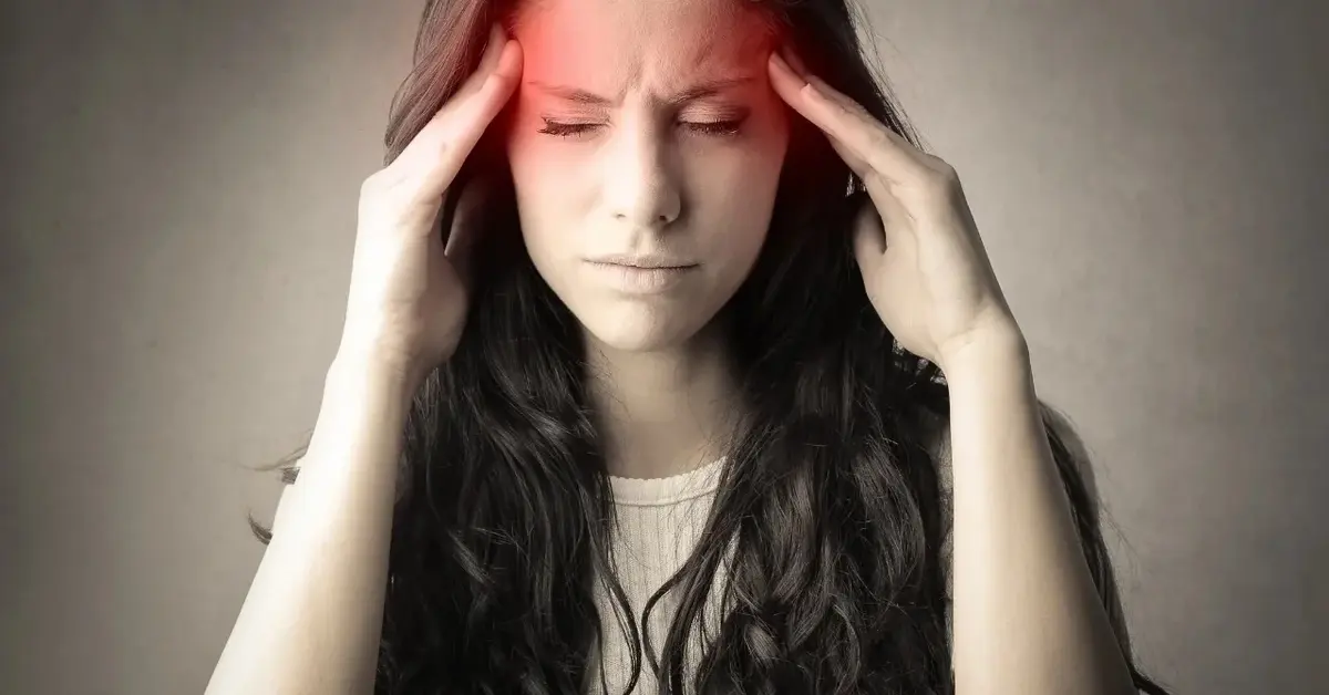 Kobieta odczuwająca ból głowy w skroniach