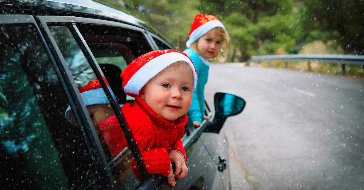 Dzieci wystawiające głowy z okien jadącego samochodu 