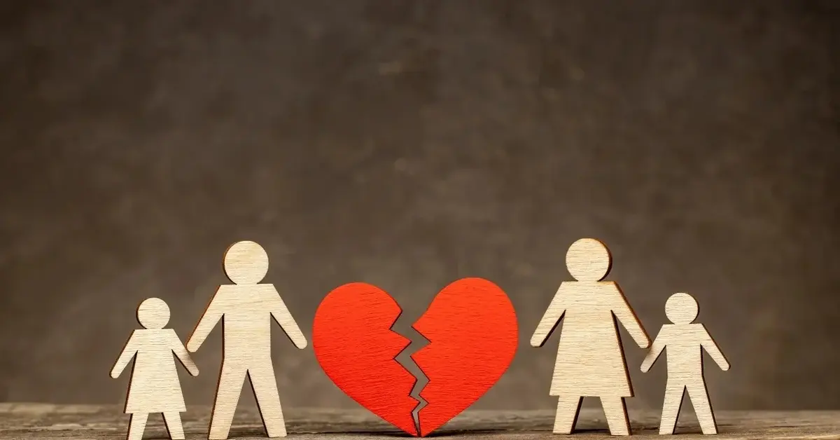 Grafika przedstawiająca pęknięte serce po którego dwuch stronach stoją figurki kobiety, mężczyzny i dwójki dzieci