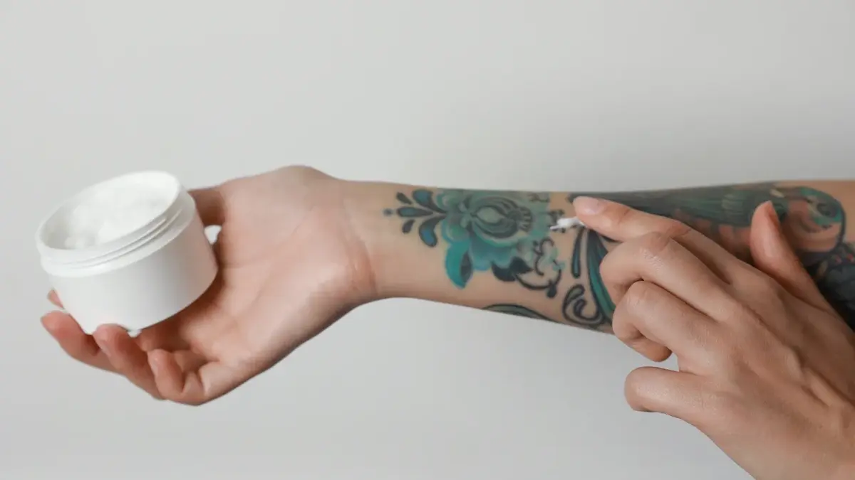 smarowanie kremem tatuażu na ręce kobiety 