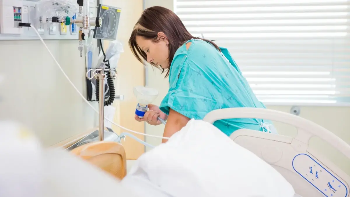 Kobieta odczuwająca skurcze porodowe na szpitalnym łóżku