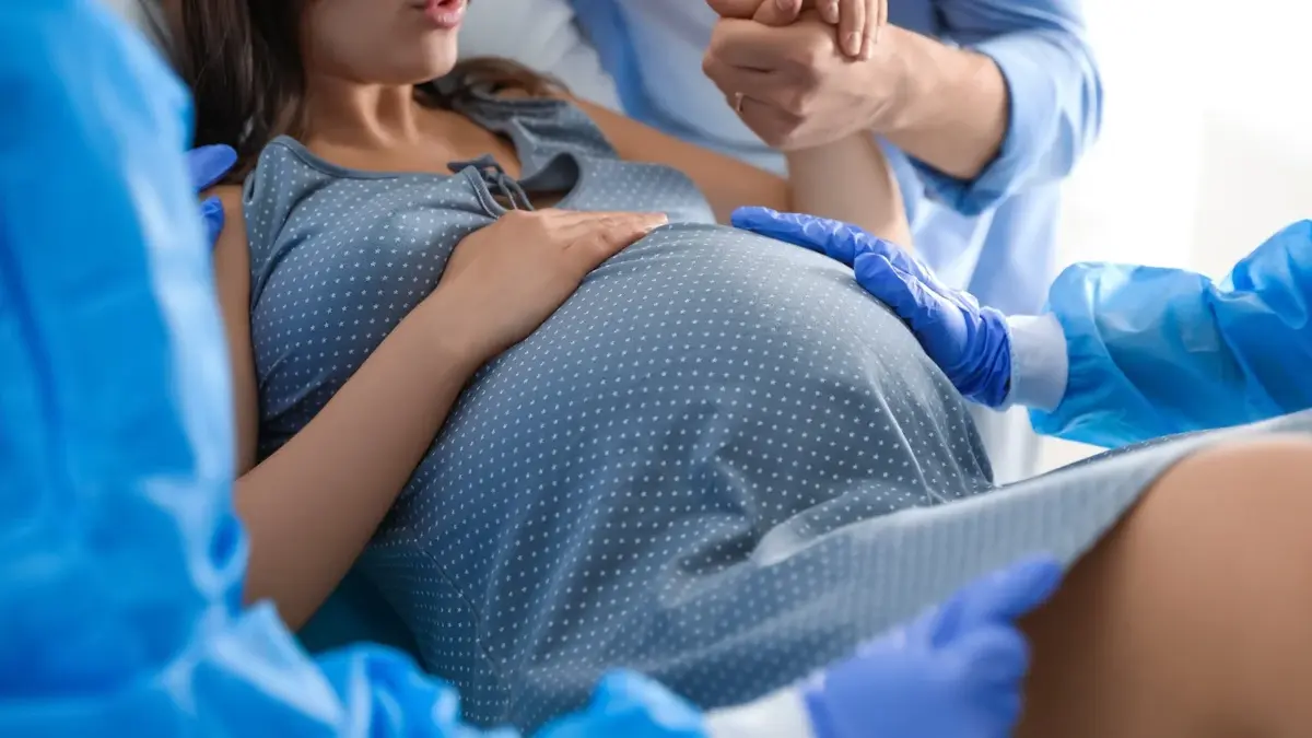 Kobieta w ciąży w niebieskiej koszuli w kropeczki