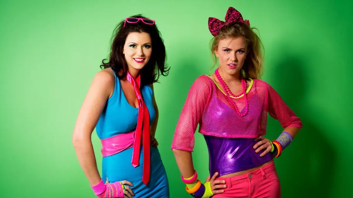 Dwie kobiety ubrane w kolorowe stroje z lat 80.