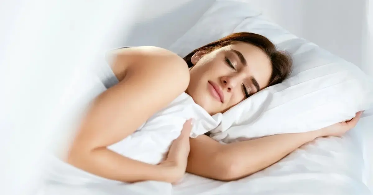 Kobieta śpiąca w białej pościeli 