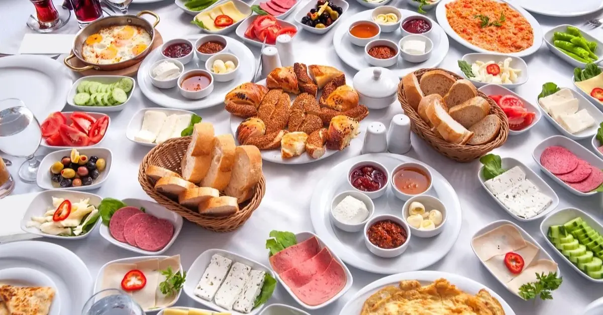 Stół śniadaniowy z wieloma daniami (chleb, wędlina, ser, dressingi)