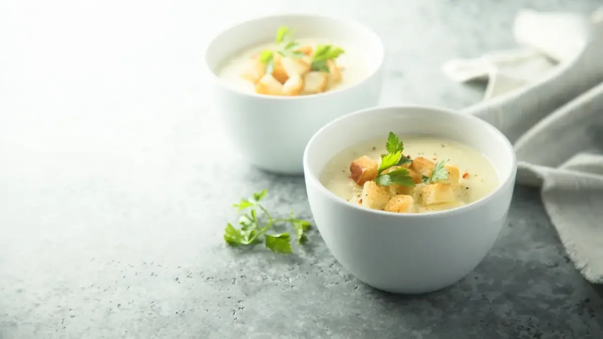 Zupa serowa z grzankami w białych miseczkach
