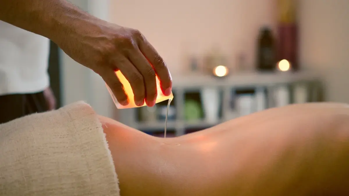 Świeca do masażu trzymana w ręce podczas masażu pleców