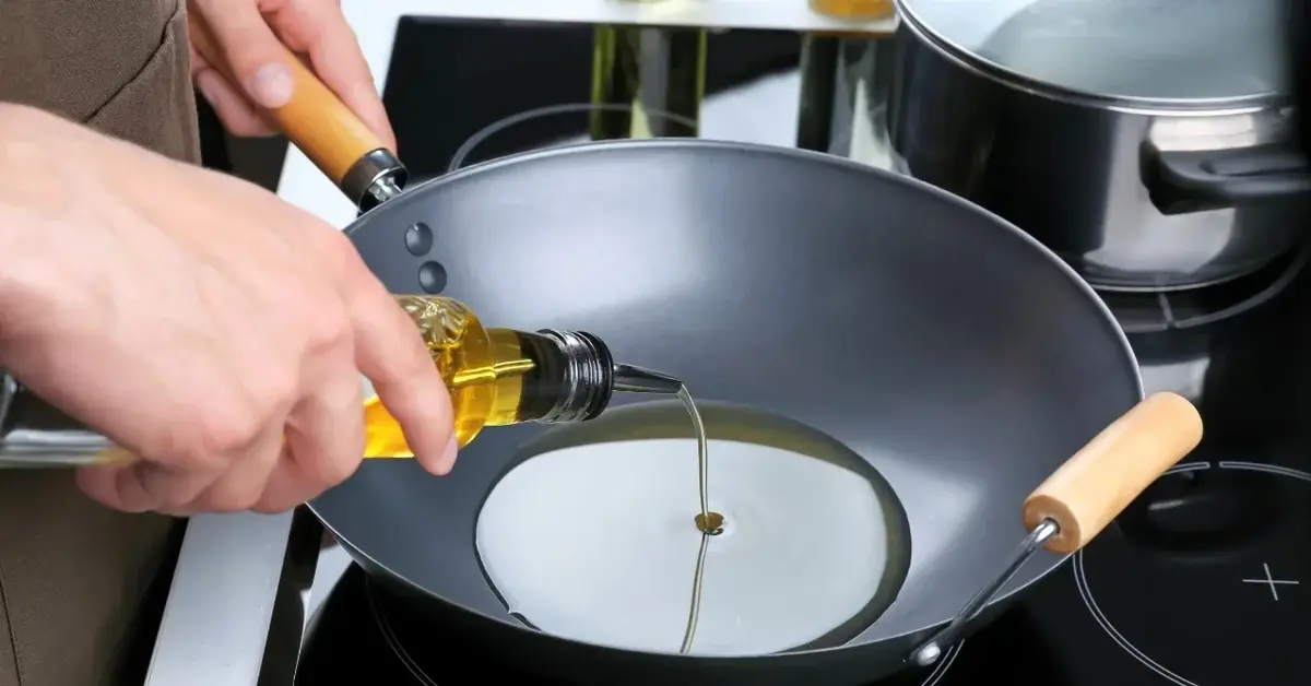 Olej nalewany na wok stojący na kuchence