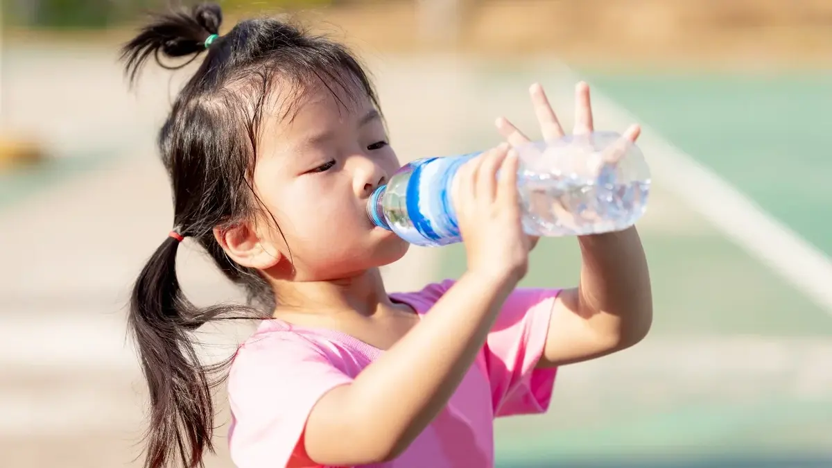 Dziewczynka pijąca wodę z butelki 