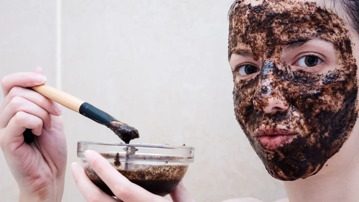 Kobieta z nałożonym na twarz domowym peelingiem z kawy