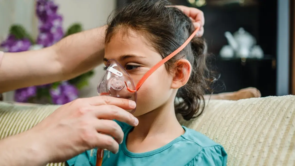 Dziewczynka podczas zakładania maski do nebulizacji