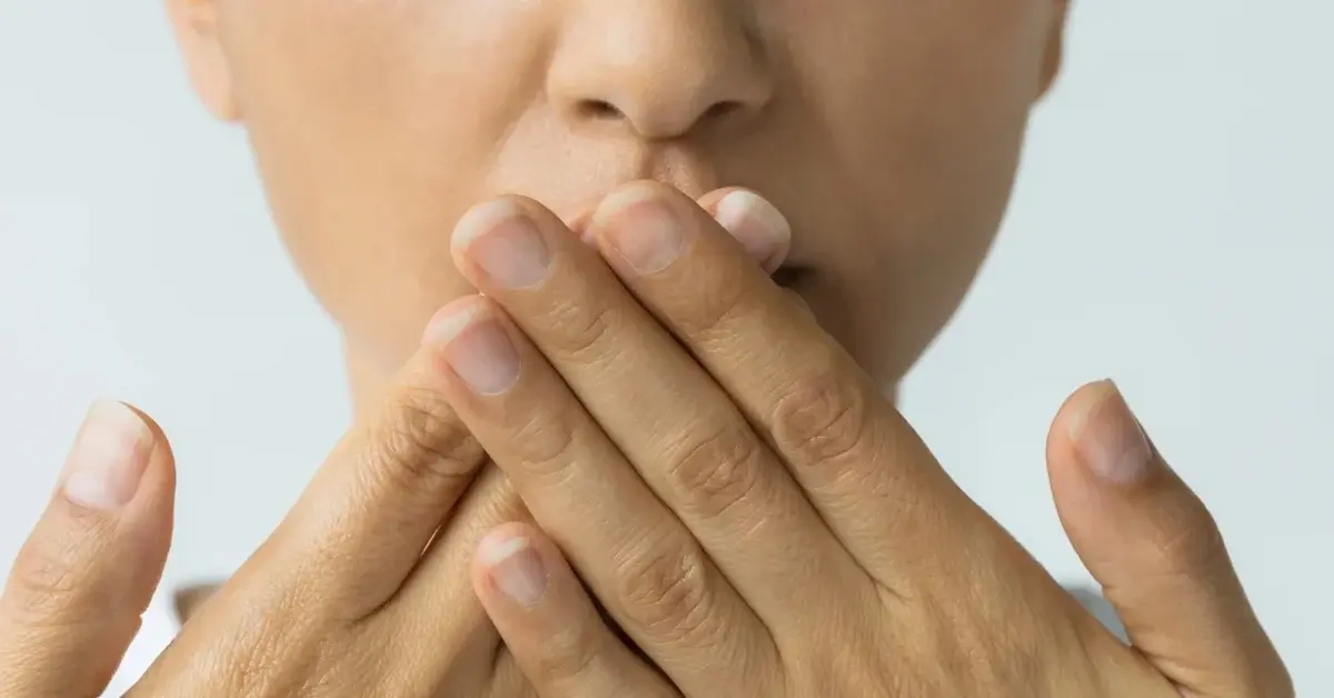 Kobieta zasłaniająca usta rękami 
