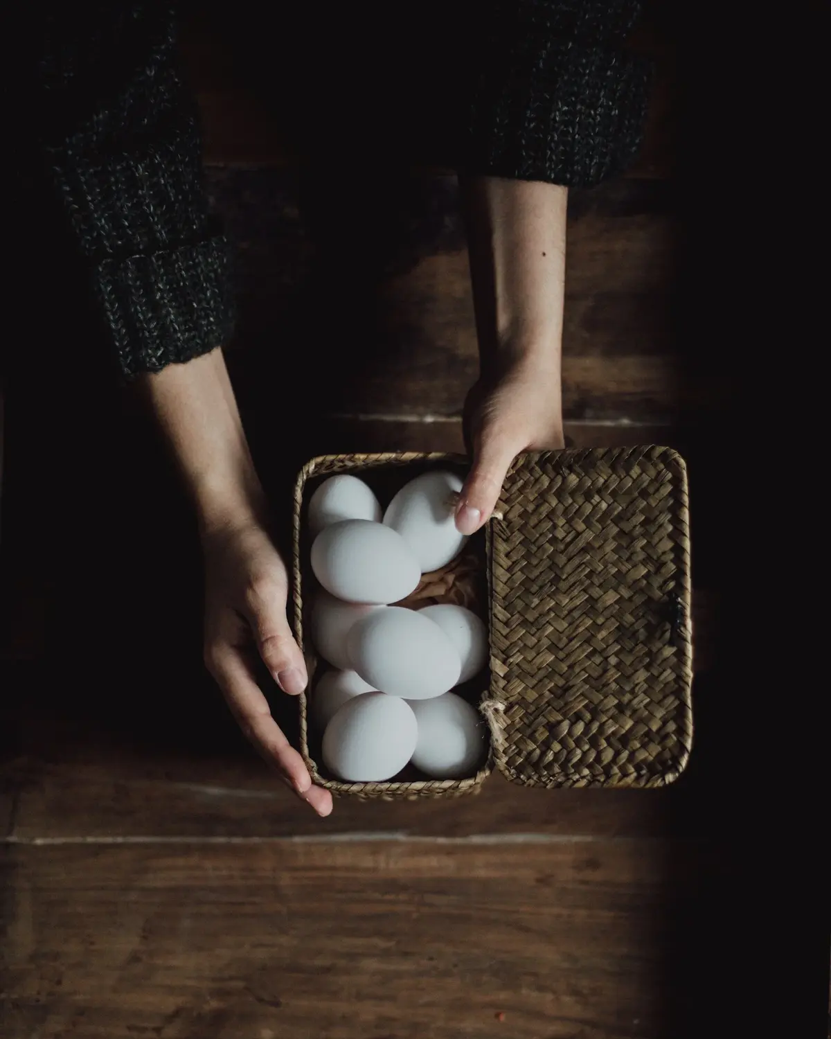 Kobieta trzyma dłonie na kurzych jajkach