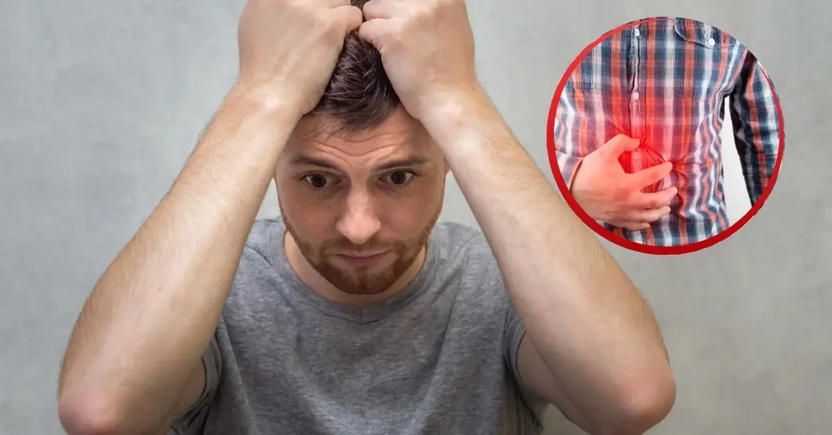 Zdenerwowany mężczyzna z nerwicą żołądka trzyma się za głowę.