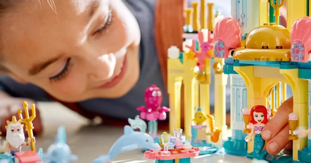Uśmiechnięta dziewczynka bawi się radośnie zestawami LEGO Disney Princess