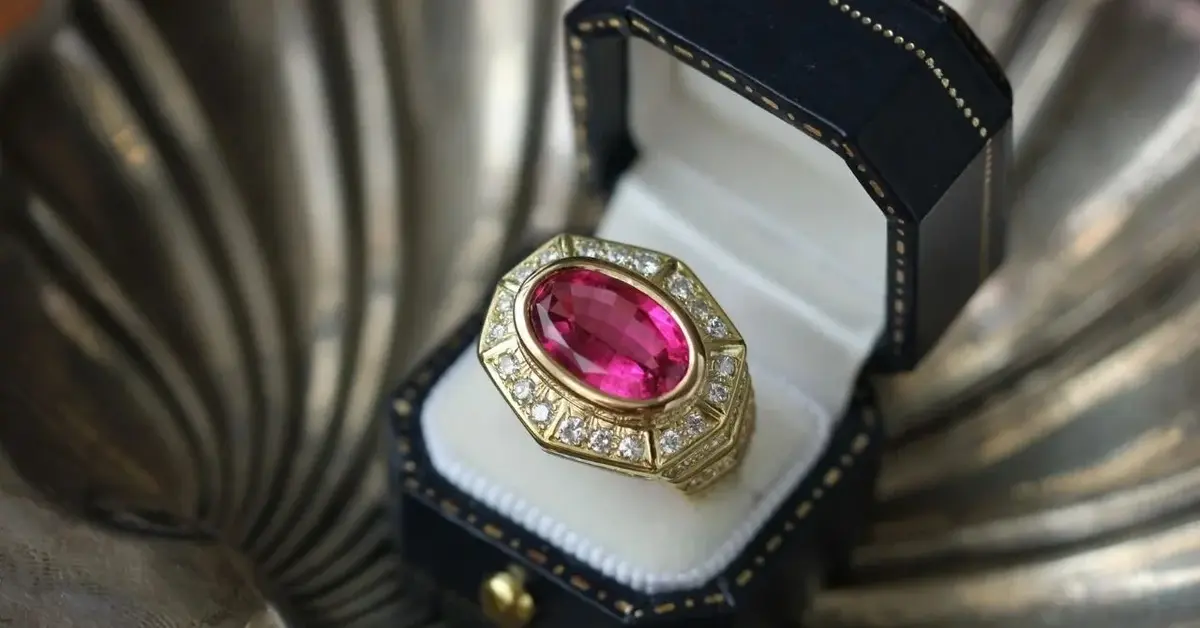 Złoty pierścionek w antycznym stylu z dużym kamieniem szlachetnym, umieszczony w eleganckim pudełku