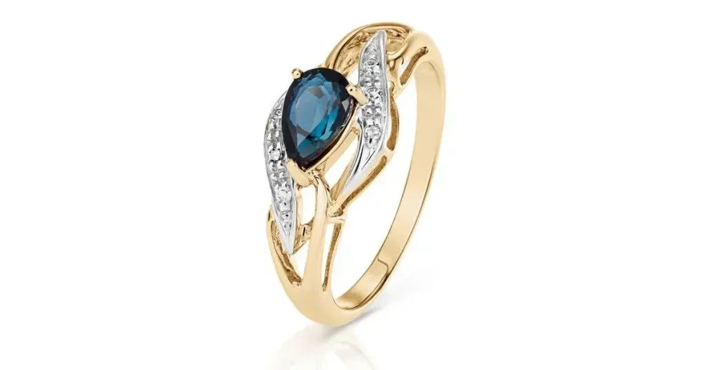  Złoty pierścionek z niebieskim oczkiem na białym tle
