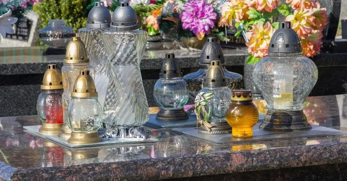 Znicze i kwiaty stojące na grobach na Wszystkich Świętych.