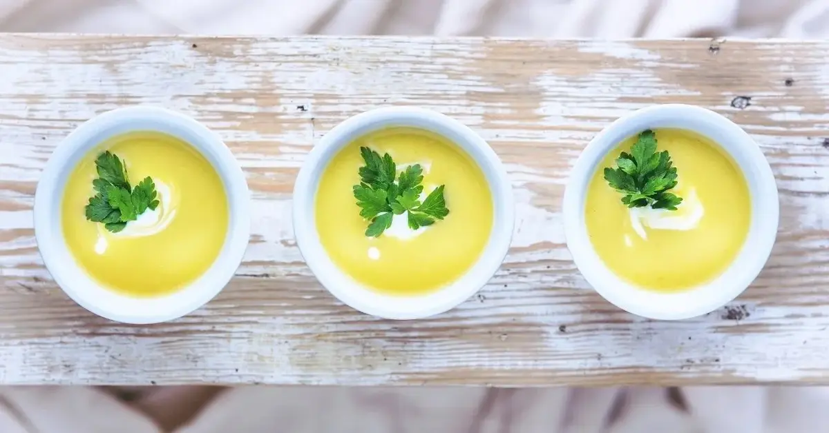 zupa ziemniaczana z mascarpone w trzech białych miseczkach ustawionych na desce