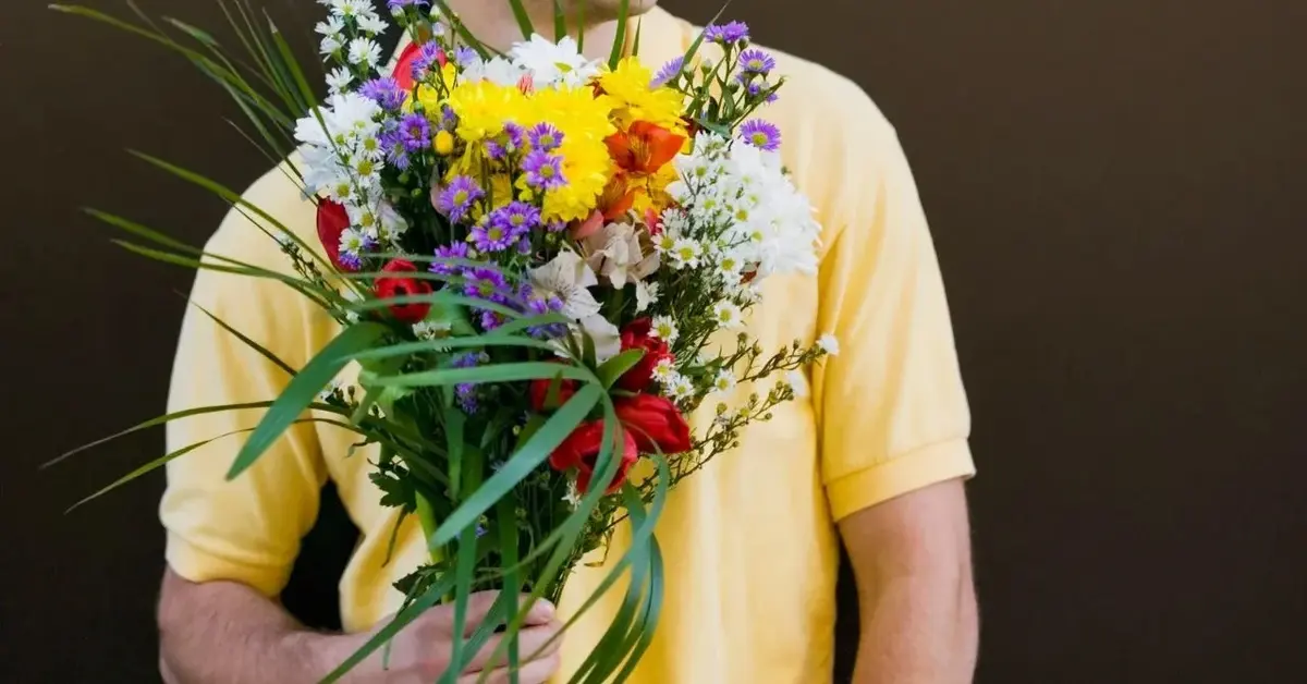 mężczyzna trzymający kwiaty na imieniny haliny